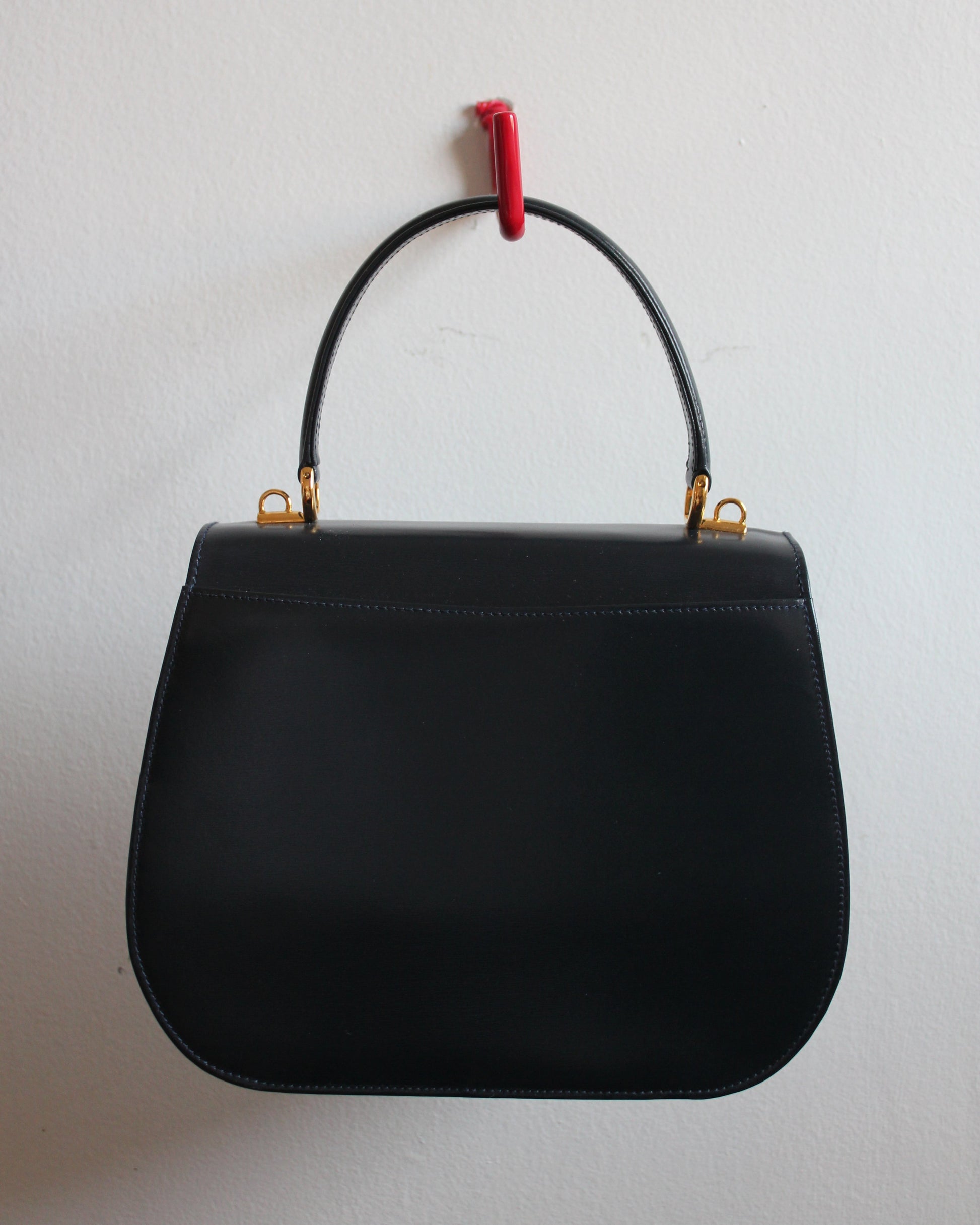 back of vintage navy gucci calfskin handbag with gold hardware