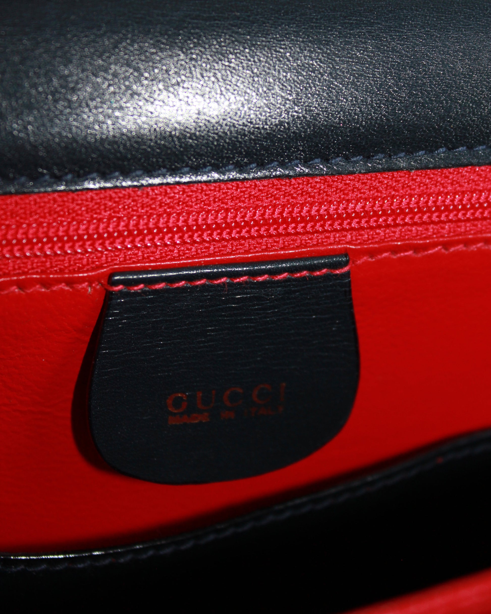 interior gucci label on vintage navy calfskin handbag with red leather interior