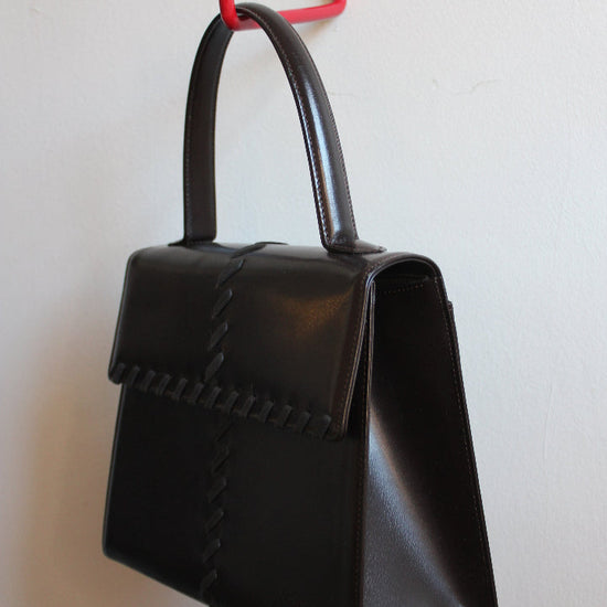 Side view of chocolate brown top handle YSL bag from the 70s